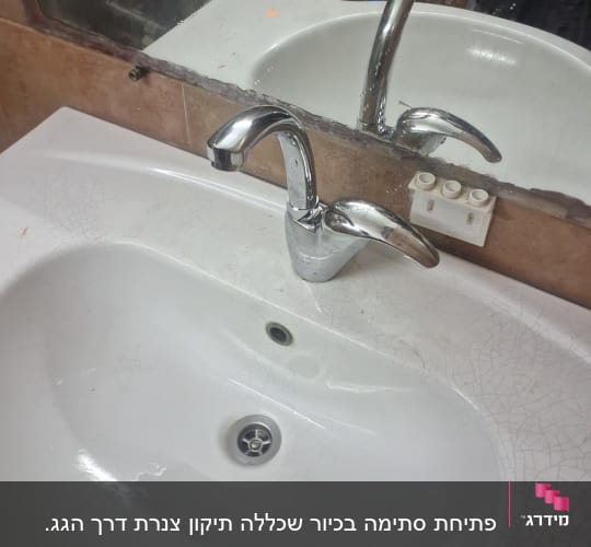 כיור עם ברז כרום ומראה מלוכלכת